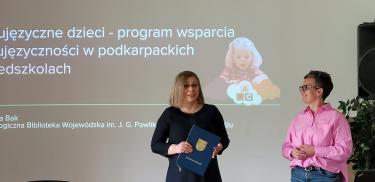 Prelegentki Dorota Grząba i Barbara Bak podczas wystąpienia, w tle slajd prezentacji